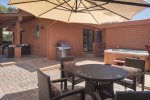 A view of the patio with outdoor dining table, BBQ grill, private hot tub and patio furniture